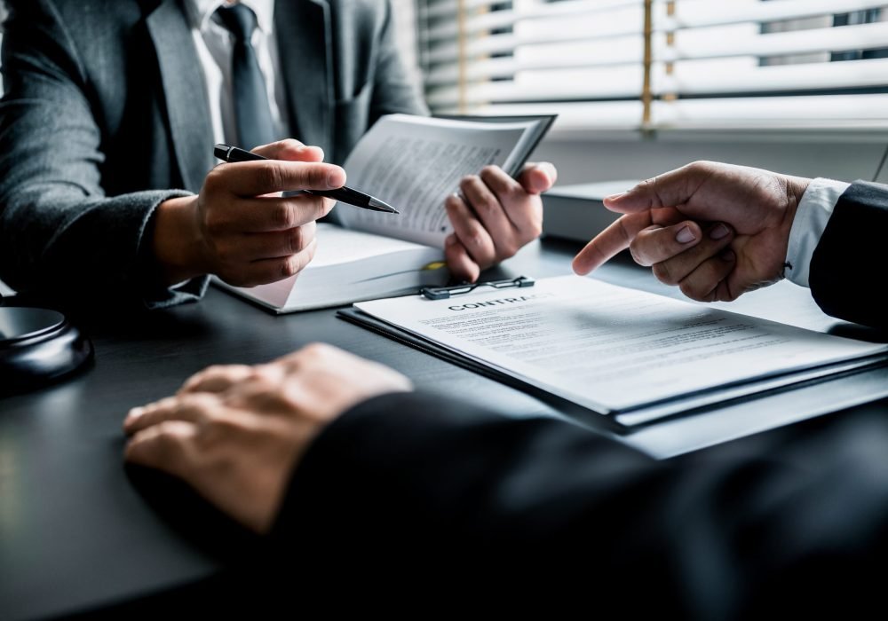 Close up of businessmen or lawyers discussing contract or business agreement at law firm office, Business people making deal document legal, justice advice service concept.